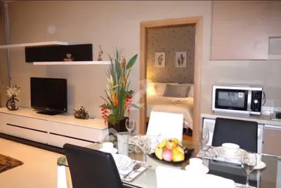 Modern open-plan living and dining area with stylish decor and cozy bedroom view.