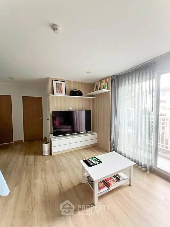 Modern living room with sleek TV unit and large window for natural light