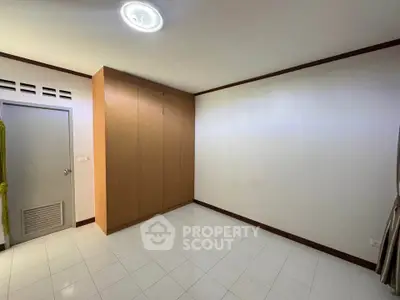 Spacious empty room with built-in wardrobe and tiled floor, perfect for customization.