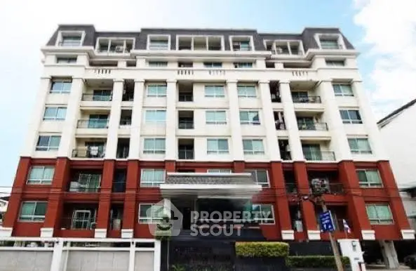 Modern multi-story residential building with elegant facade and large windows.