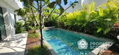 Luxurious private pool surrounded by lush greenery in modern villa setting.