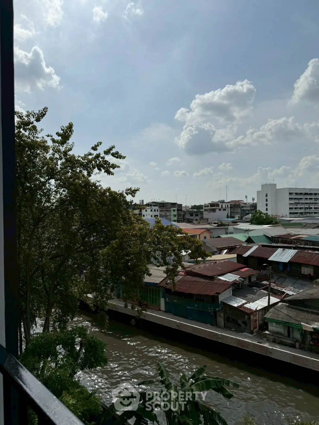 Scenic urban view from a balcony overlooking a canal and city skyline.