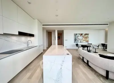 Luxurious open-plan kitchen and living room with modern marble island and elegant decor.