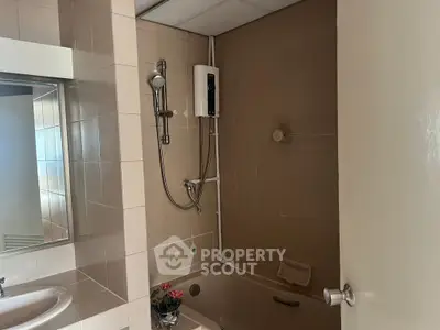 Cozy bathroom with bathtub and modern shower fixtures in a well-maintained apartment.