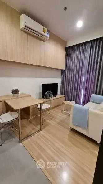 Modern living room with wooden flooring, cozy seating, and stylish decor in a contemporary apartment.