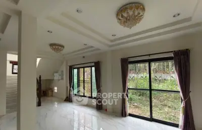 Spacious living room with elegant lighting and large windows overlooking greenery.