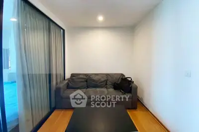 Cozy living room with modern sofa and glass partition, perfect for relaxation.