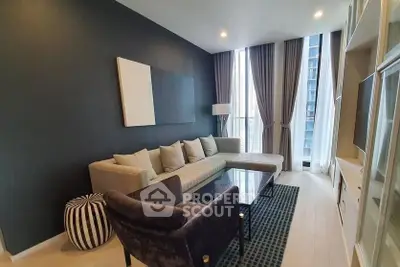 Modern living room with stylish furniture and floor-to-ceiling windows in a high-rise apartment.