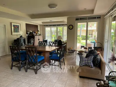 Spacious living room with elegant dining area and garden view, perfect for family gatherings.