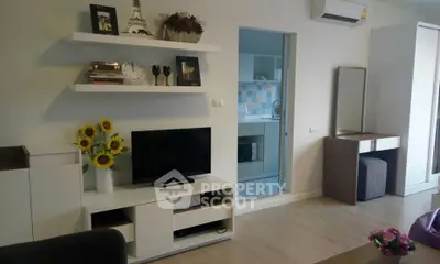 Modern living room with stylish decor and open view into a contemporary kitchen.