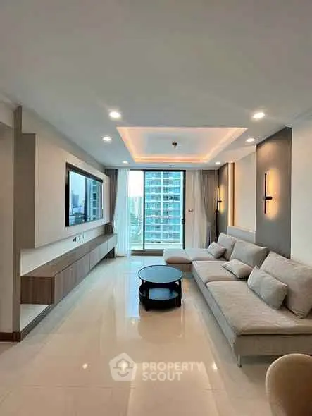 Spacious modern living room with elegant decor and large windows offering city views.