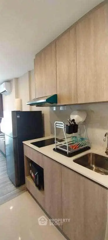 Modern kitchen with sleek cabinetry and stainless steel appliances in a stylish apartment.