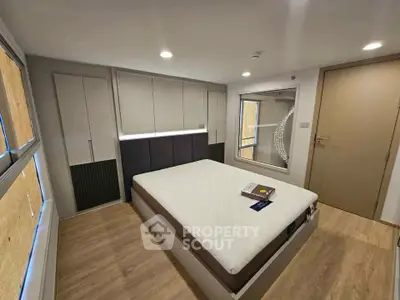 Modern bedroom with minimalist design and ample storage space, featuring a comfortable bed and stylish decor.
