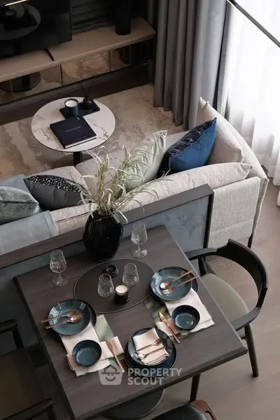 Stylish modern living room with elegant dining setup and cozy seating area, perfect for entertaining guests.