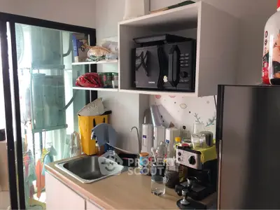 Cozy kitchen with modern appliances and balcony view, perfect for urban living.