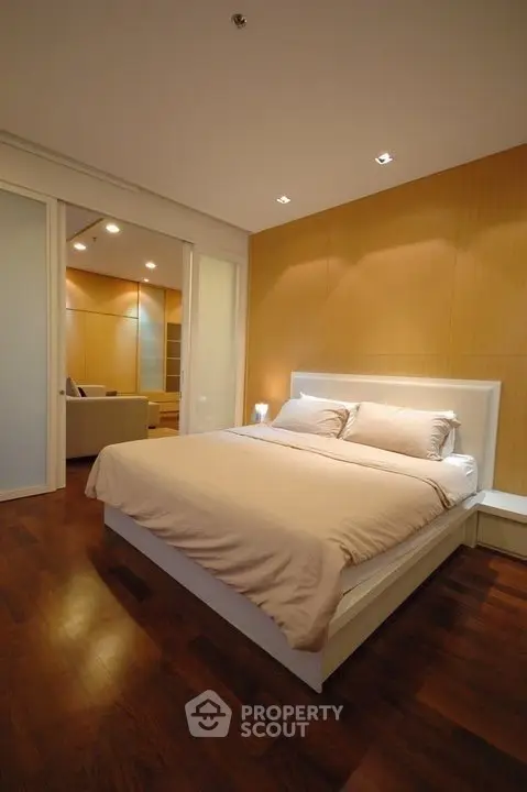 Spacious modern bedroom with wooden flooring and elegant lighting