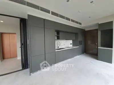 Modern kitchen with sleek cabinetry and marble backsplash in luxury apartment.