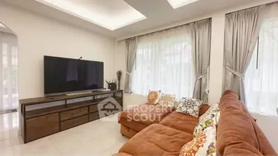 Spacious living room with cozy sectional sofa and large TV, perfect for family gatherings.