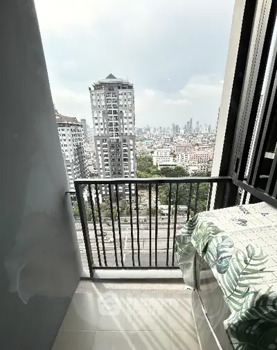 Stunning city view from a high-rise balcony with modern railing and tiled floor.