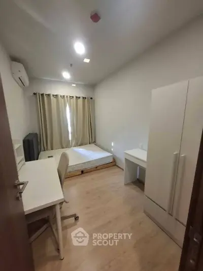 Cozy bedroom with modern furniture and natural light, perfect for a comfortable living experience.