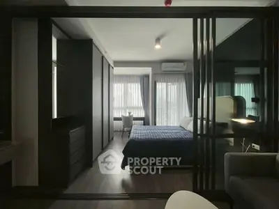 Modern bedroom with large windows and sleek furnishings in a stylish apartment.