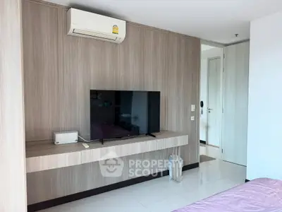 Modern bedroom with wall-mounted TV and air conditioning in a stylish apartment.