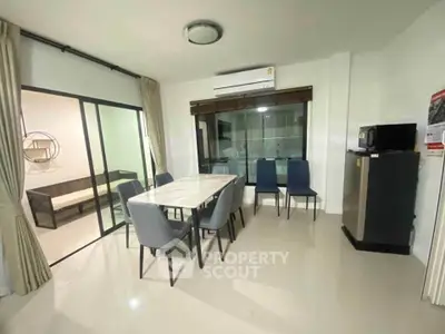 Modern dining area with sleek table and chairs, adjacent to a cozy living space, perfect for entertaining.