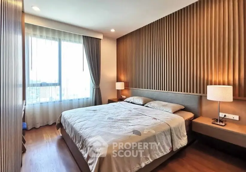 Modern bedroom with wooden accents and large window for natural light.