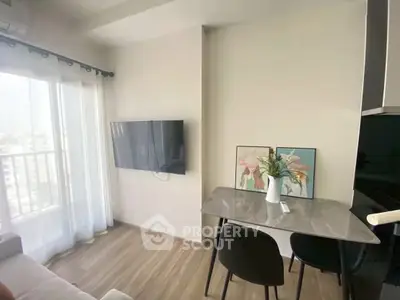 Modern living room with wall-mounted TV and dining area in a bright apartment.
