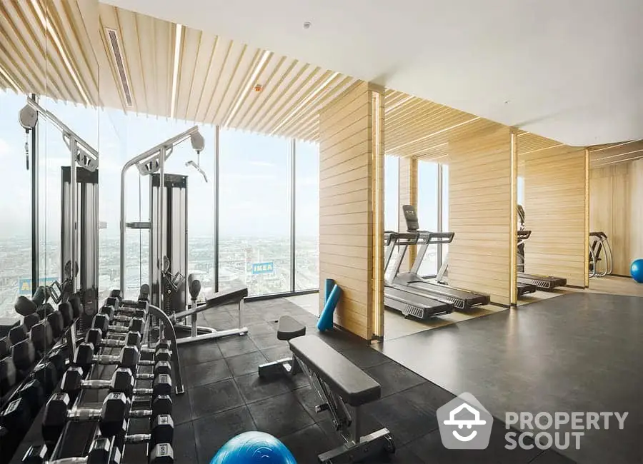 Luxurious high-rise gym with panoramic city views and modern fitness equipment.