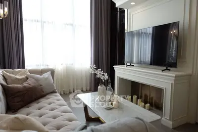 Elegant living room with plush sofa, large TV, and stylish decor
