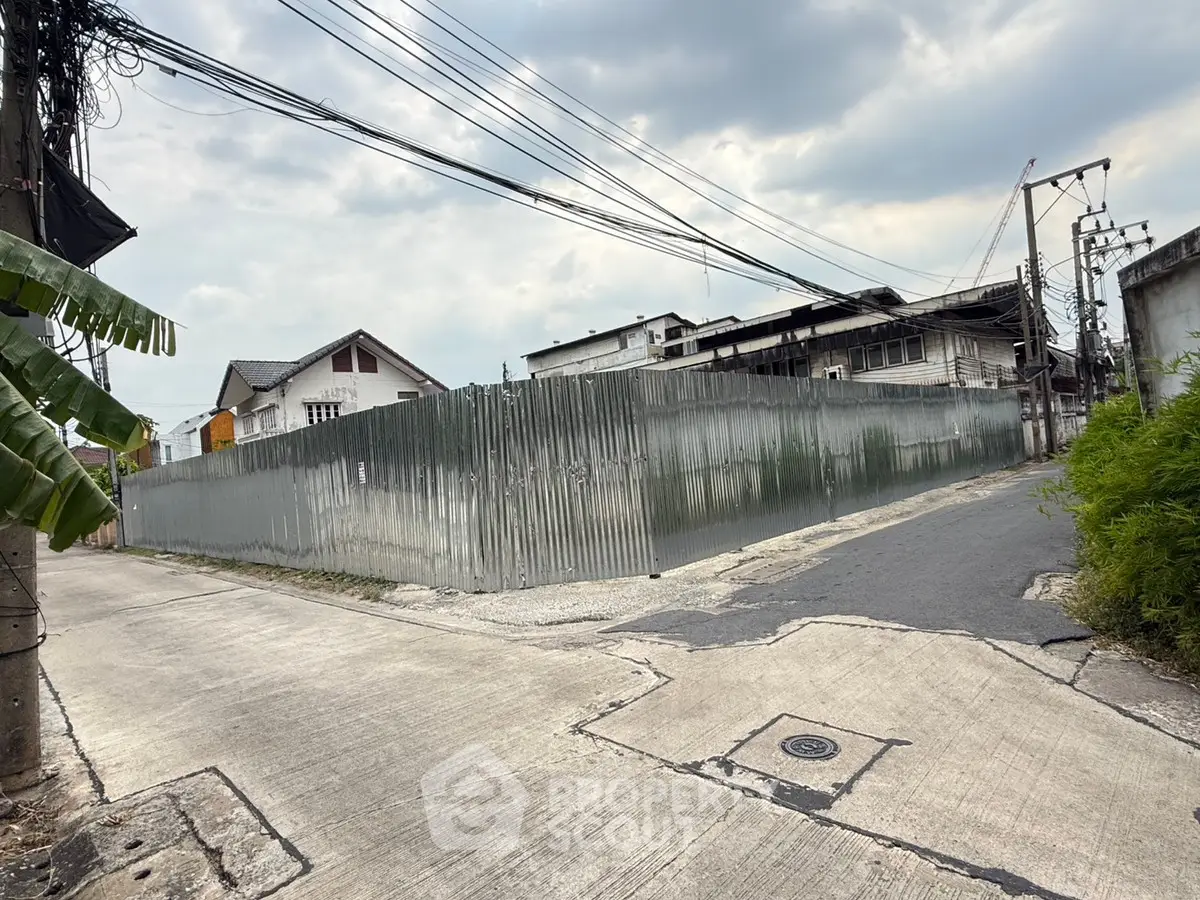 Vacant land with metal fencing in urban area, potential for development.