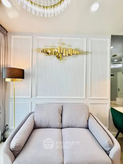 Elegant living room with modern decor and plush gray sofa, featuring stylish wall art and ambient lighting.