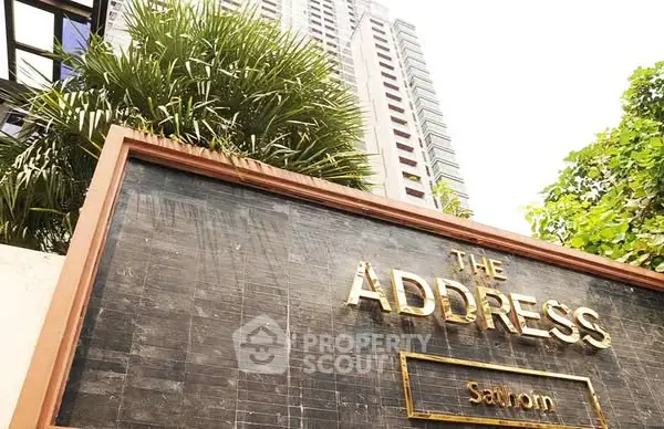 Luxurious high-rise building with elegant signage at The Address Sathorn.