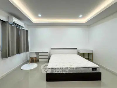 Spacious bedroom with modern design, featuring a comfortable bed, sleek furniture, and ambient lighting.