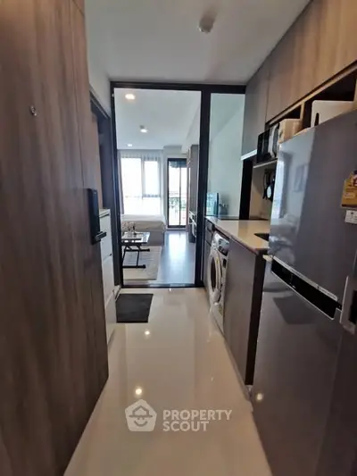 Modern apartment hallway with sleek kitchen appliances and bright natural light