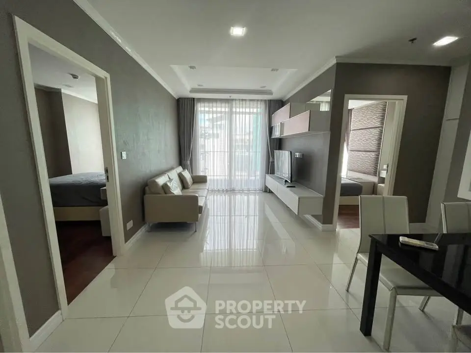 Spacious modern living room with sleek furniture and large windows in a stylish apartment.