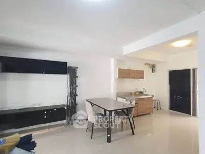 Modern open-layout kitchen with dining area and sleek cabinetry in a bright apartment.