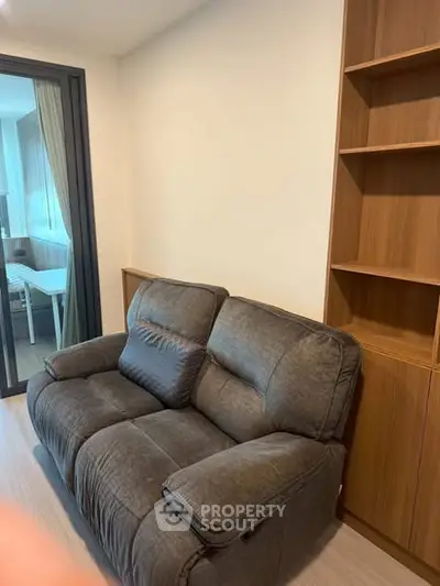 Cozy living room with plush sofa and built-in wooden shelves, perfect for relaxation and storage.