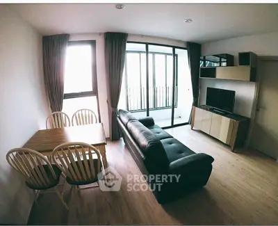 Modern living room with sleek furniture and large windows offering natural light.