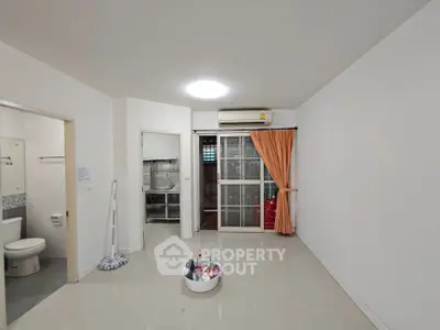 Spacious unfurnished living room with air conditioning and adjacent bathroom, ideal for customization.