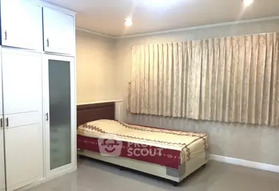 Cozy bedroom with single bed and built-in wardrobe, perfect for minimalist living.