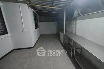 Spacious utility room with stainless steel countertops and ample storage space.
