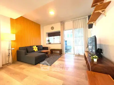 Modern living room with stylish decor, wooden flooring, and cozy seating area.
