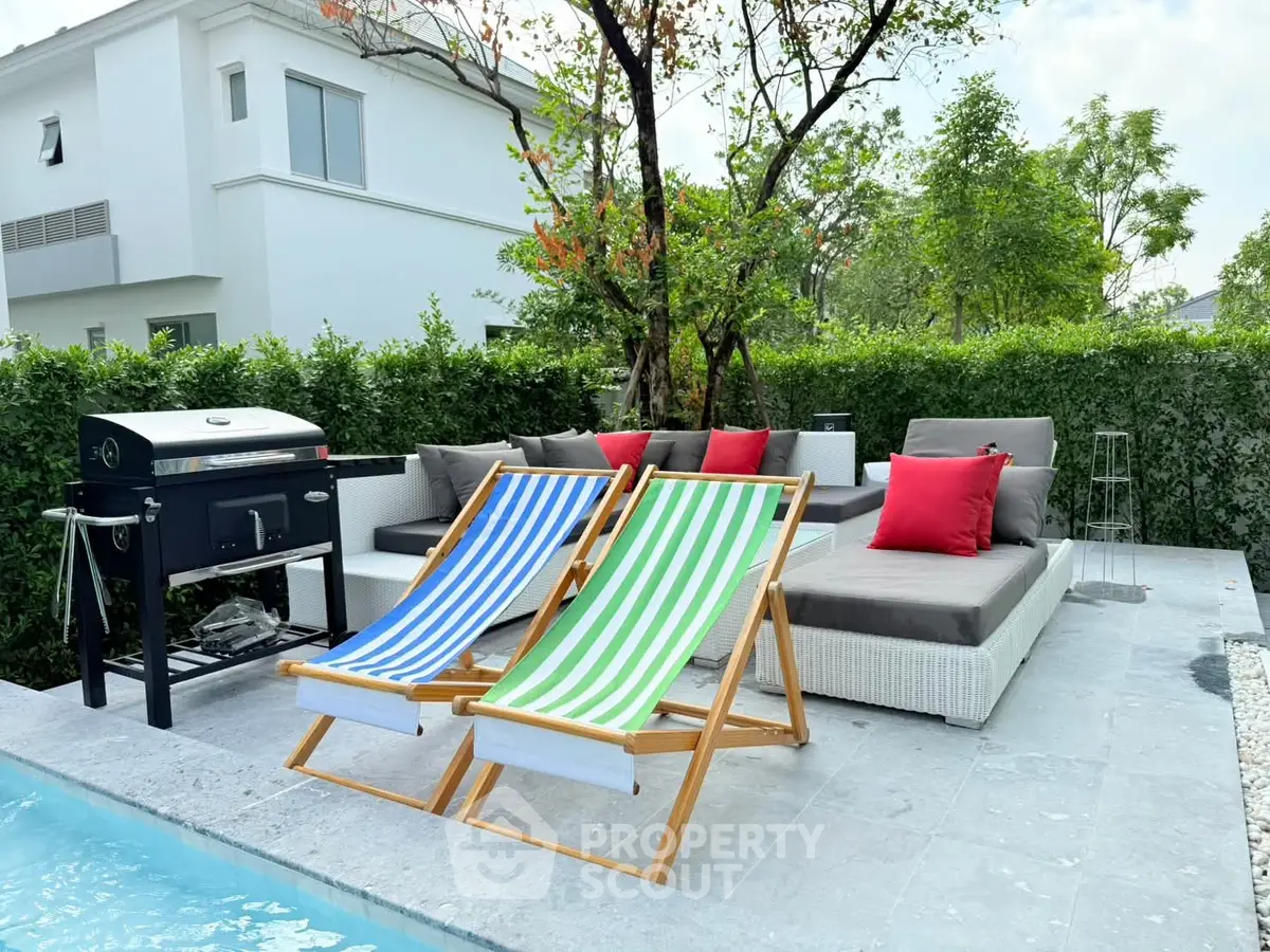 Luxurious outdoor patio with poolside seating and BBQ grill in modern home