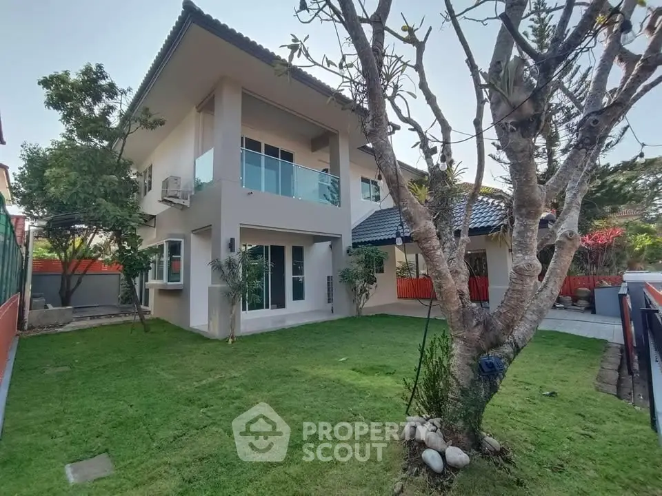 Charming two-story house with lush garden and modern architecture, perfect for family living.