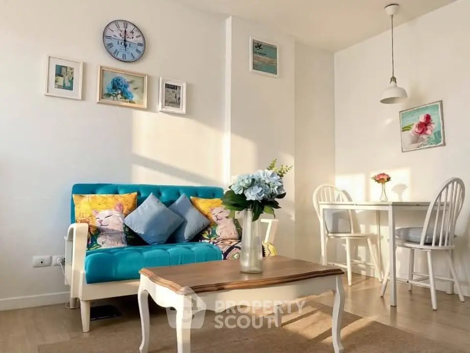 Charming living room with stylish decor and natural light, featuring a cozy sofa and elegant dining area.