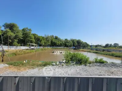 Scenic view of rural land with pond and lush greenery, ideal for development or agriculture.