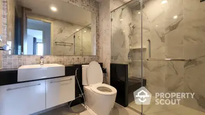 Modern bathroom with glass shower and elegant fixtures in luxury apartment