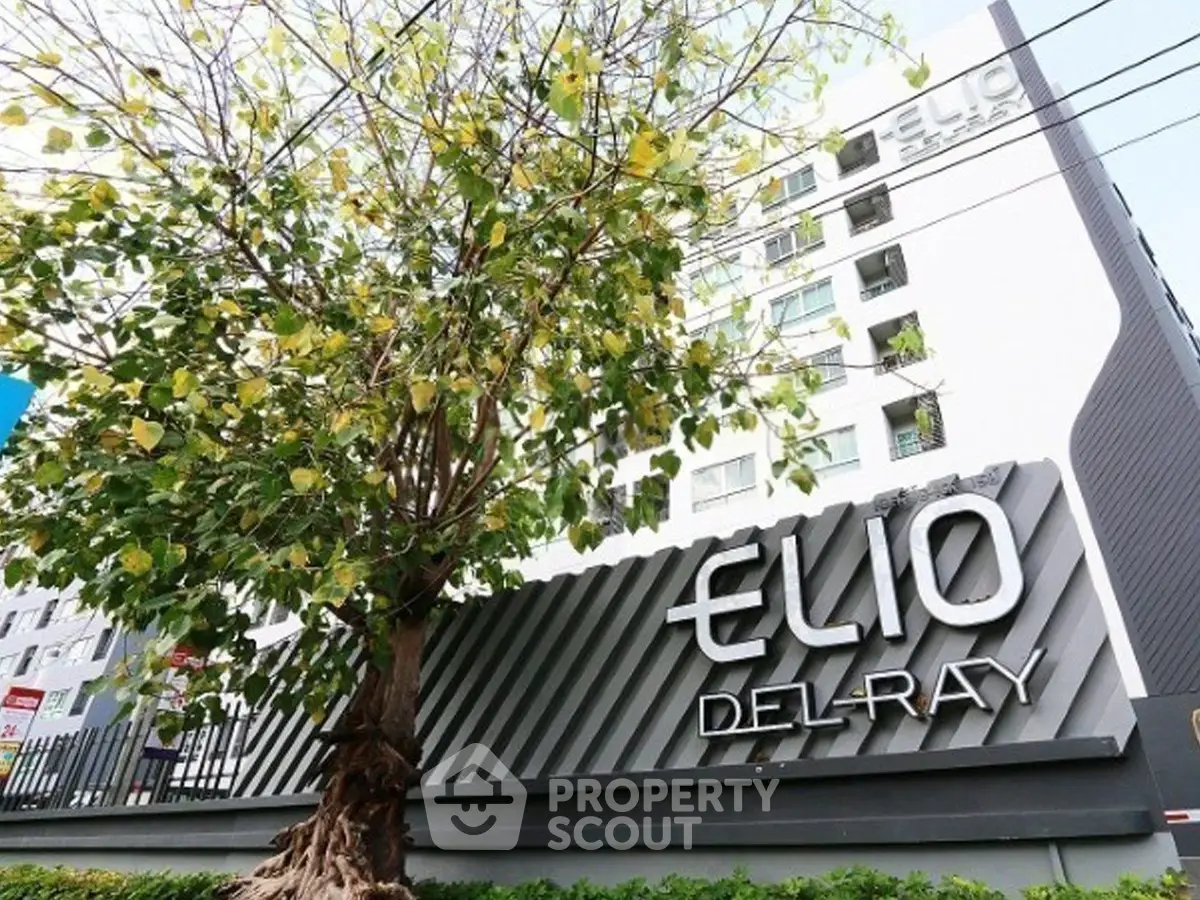 Modern Elio Del Ray building exterior with lush tree and sleek signage.
